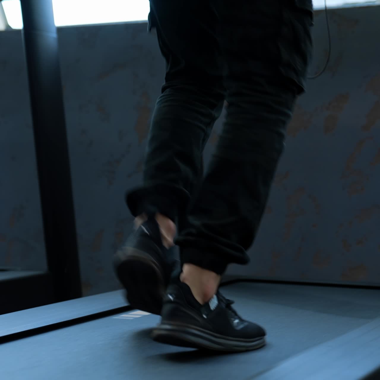 Male training in sport club. Close up of athletic feet running on treadmill in fitness gym