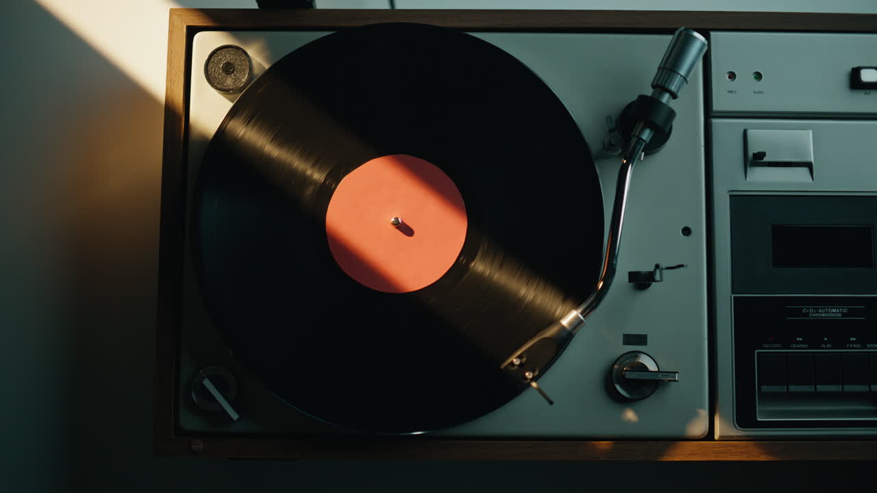 Hand turning switch vinyl player standing at surface under gold evening light