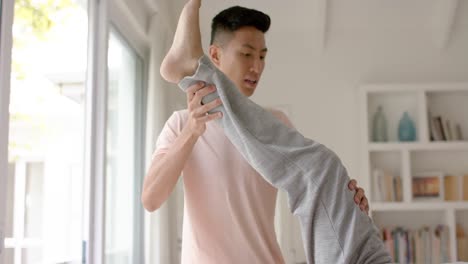 diverse male physiotherapist advising and senior male patient stretching, in slow motion