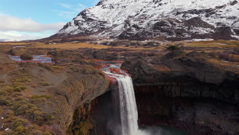 aerial view of el salto del agrio waterfall in caviahue, neuquén, argentina, with snowy andean mountains in background