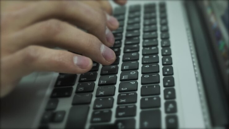 Person Typing on Laptop Keyboard