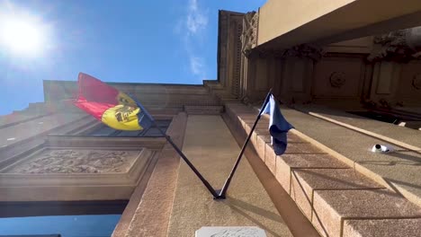 Facade-flagpole-with-flag-of-Moldova-and-European-union,-low-angle