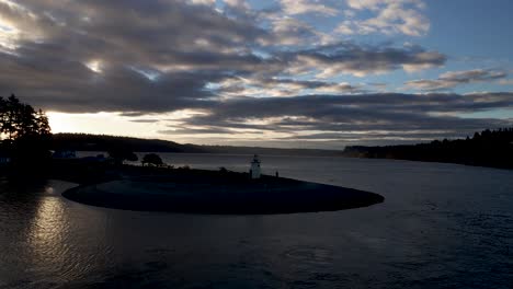 flying slow over the tiny lighthouse at the mouth of gig harbor, wa, sunrise aerial