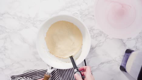 haciendo crepes en una sartén pequeña a fuego medio.