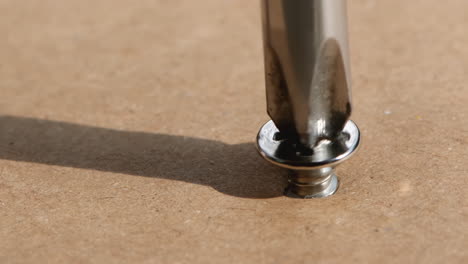 close up of screws screwed into wood with a screwdriver