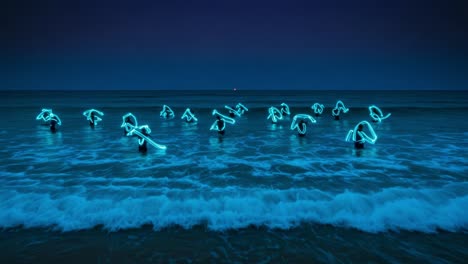 illuminated figures dancing in ocean waves: a captivating display of light and movement against the serene night sky