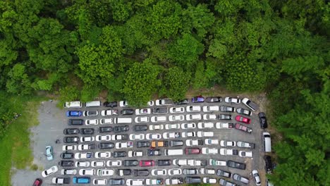 antena: el dron baja la altitud y aterriza en una camioneta encima de la zona de estacionamiento llena de autos que se quedaron en la fila esperando el ferry desde la isla de koh chang al continente, tailandia, asia