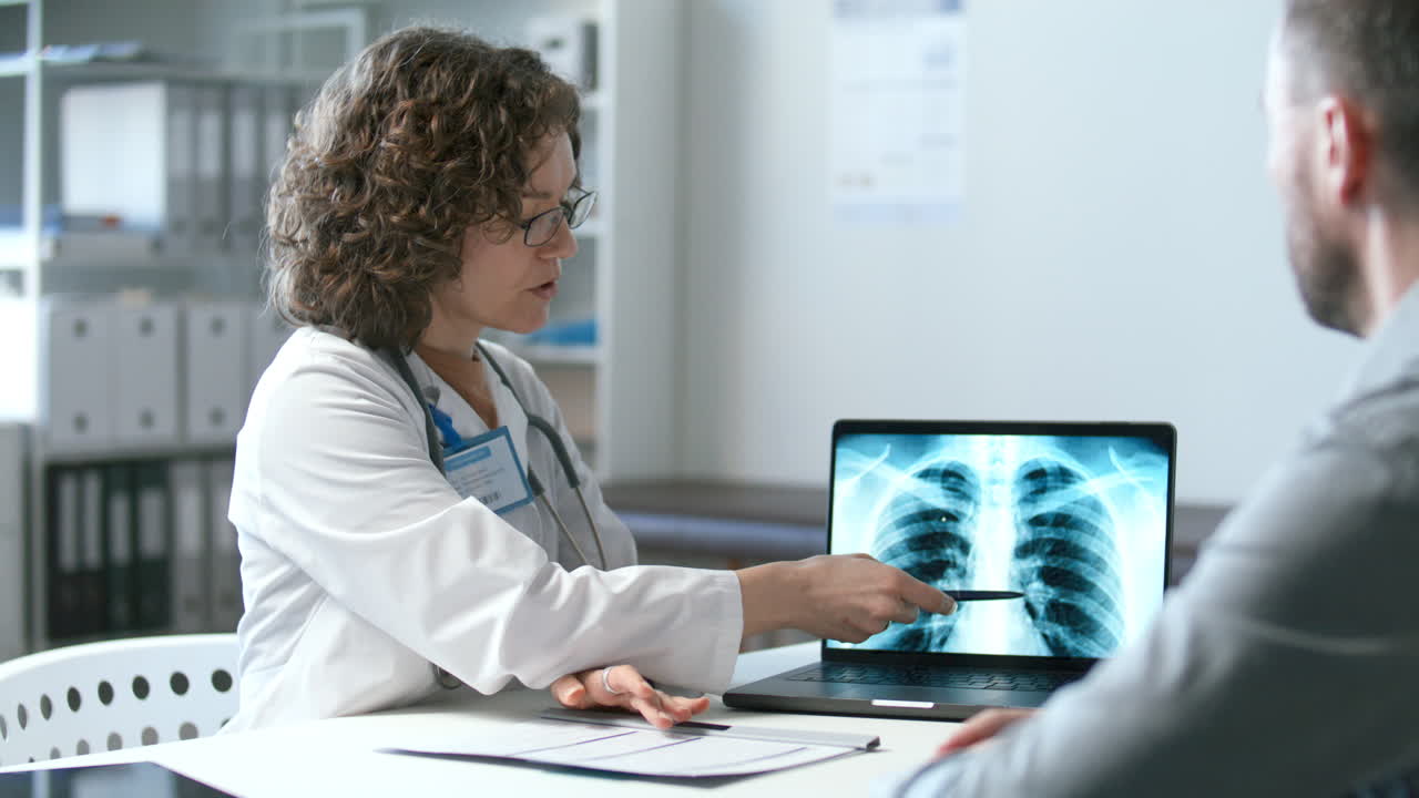 doctora explicando los resultados de la radiografía de tórax al paciente en la oficina médica
