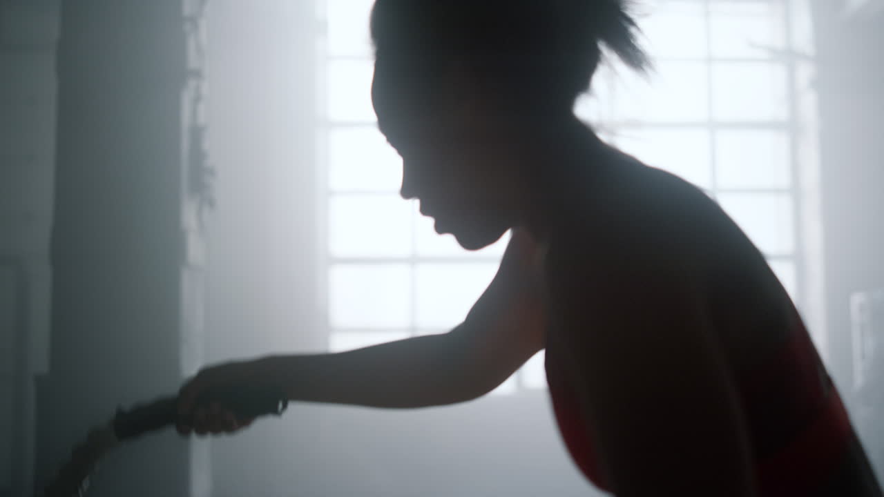 여자 운동 전투 로프 클럽에서 강력한 힘 운동에서. 실루 ⁇