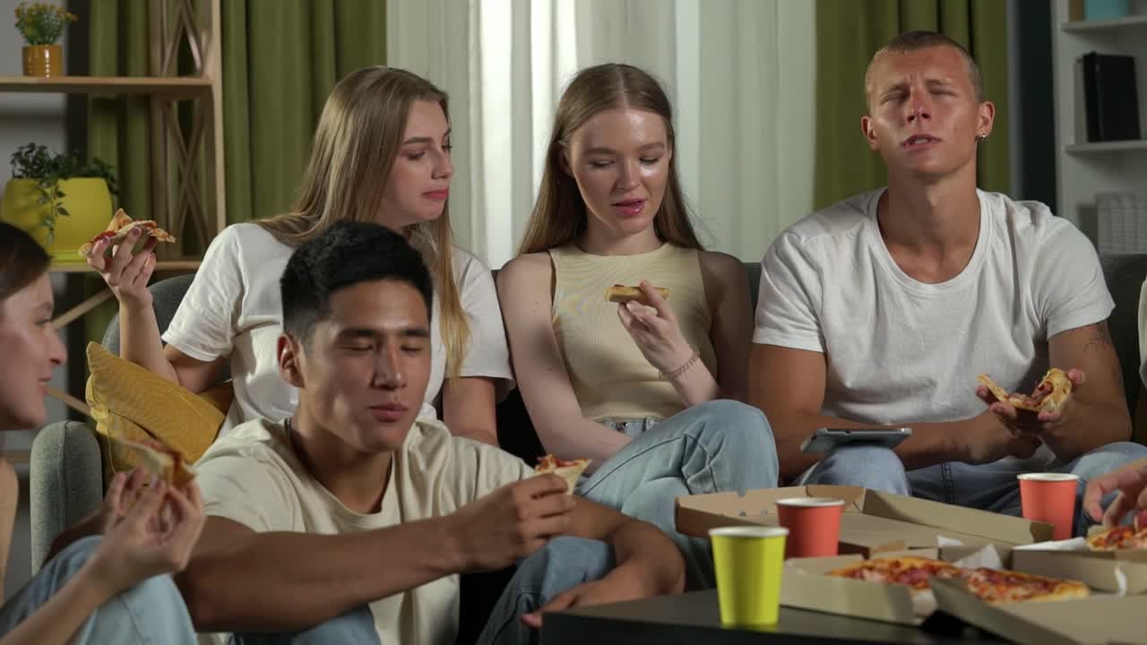 친구 들 이 집 에서 피자를 즐기고 있다