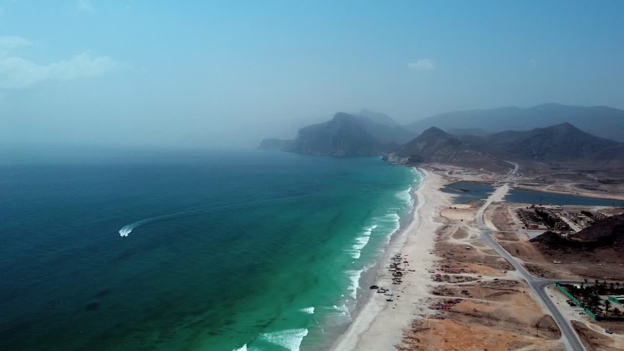 Breathtaking aerial view of Mughsail Beach, Oman! White sands, turquoise waters, and dramatic cliffs. Watch now!
