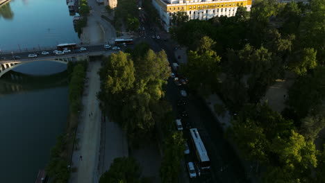 Fliegen-Sie-über-Die-Straßenbrücke-über-Den-Fluss-Guadalquivir-In-Der-Stadt-Sevilla-Im-Morgengrauen-In-Andalusien,-Spanien