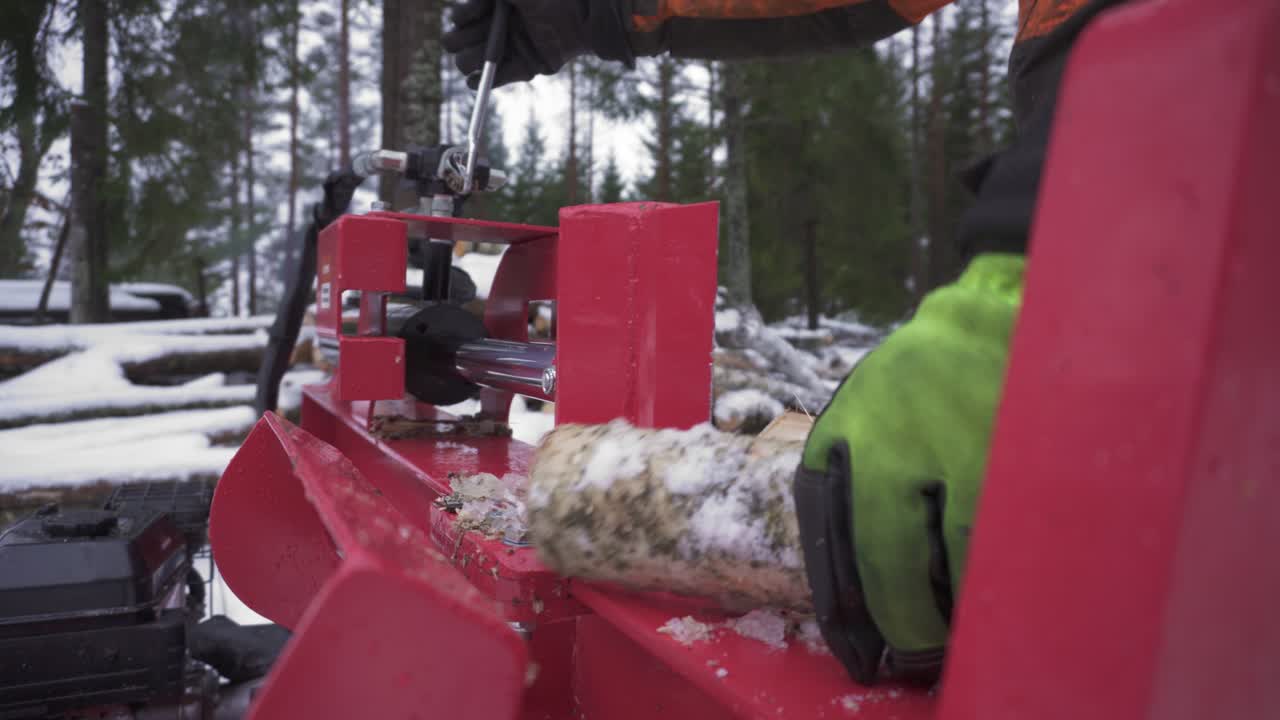 Hands In Gloves Splitting Birch Firewood With Log Splitter In Winter