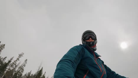 Man-snowboarding-down-snowy-mountain-in-Colorado-at-ski-resort