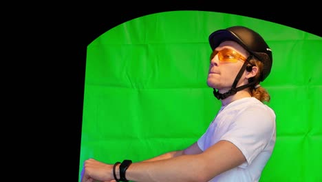 Mann-Mit-Helm-Und-Gelber-Brille,-Der-Fahrrad-Fährt-Und-Redet-–-Greenscreen-Person