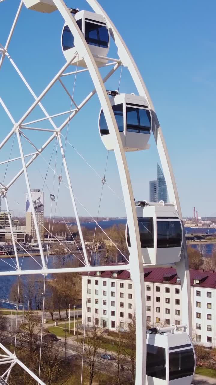 Modern Ferris wheel in Riga with cityscape and river view under a clear blue sky