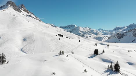 fast panoramic view of a snow-covered mountain range and fir trees in warth, a small municipality in vorarlberg, austria on a sunny day in 4k