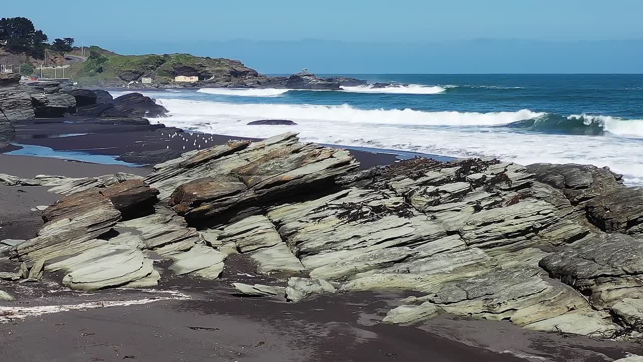 晴れた日のチリの岩だらけの海岸に打ち寄せる波