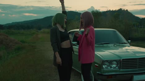 anime-style women dancing in front of a classic car at sunset