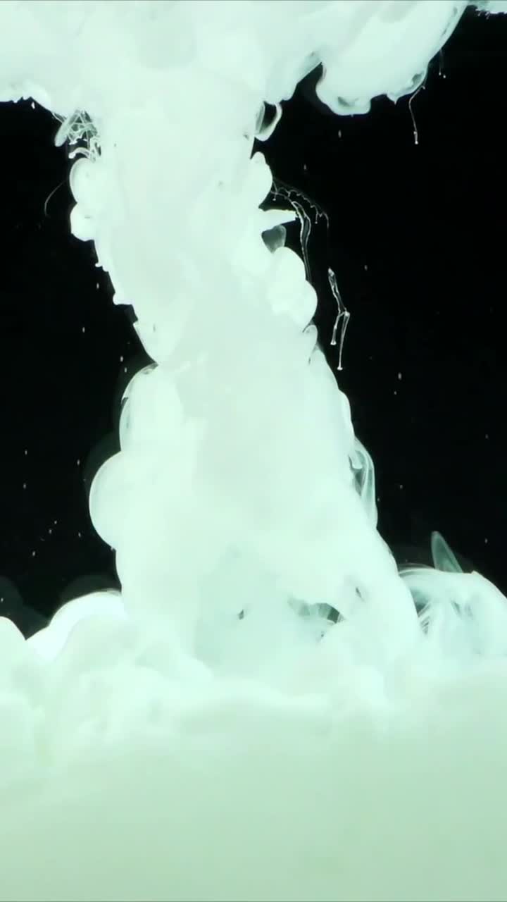 Inchiostro bianco che si dissolve e si diffonde in acqua su uno sfondo nero