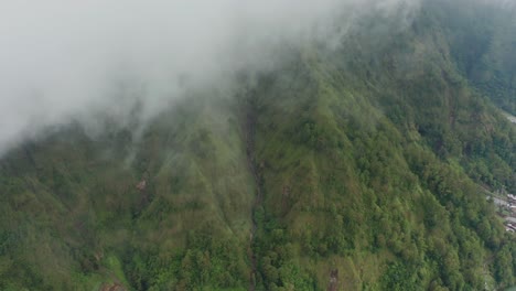 Ambiente-Brumoso-Con-Exuberante-Ladera-Verde-En-La-Caldera-Del-Lago-Batur,-Antena