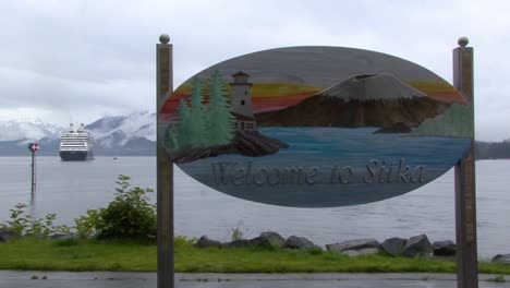 bienvenido a sitka, signo de alaska desde el muelle turístico y un crucero en el fondo