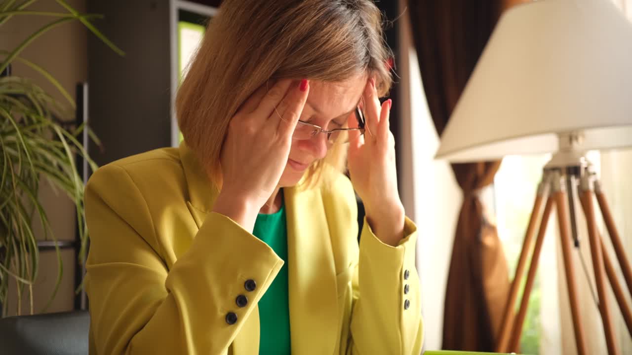 mujer de negocios cansada levantando sus gafas y masajeando sus templos película 4k