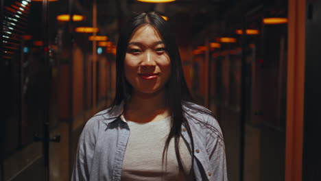 smiling young woman standing in an office hallway