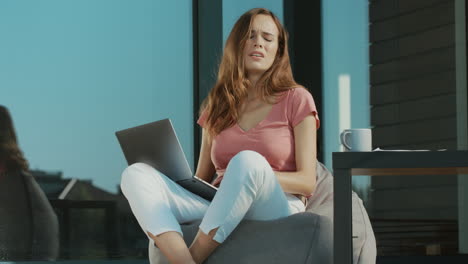 Sad-woman-working-on-laptop-outside.-Upset-woman-using-laptop-at-bagchair.