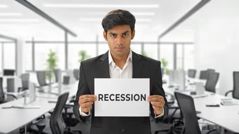 angry indian manager holding recession banner