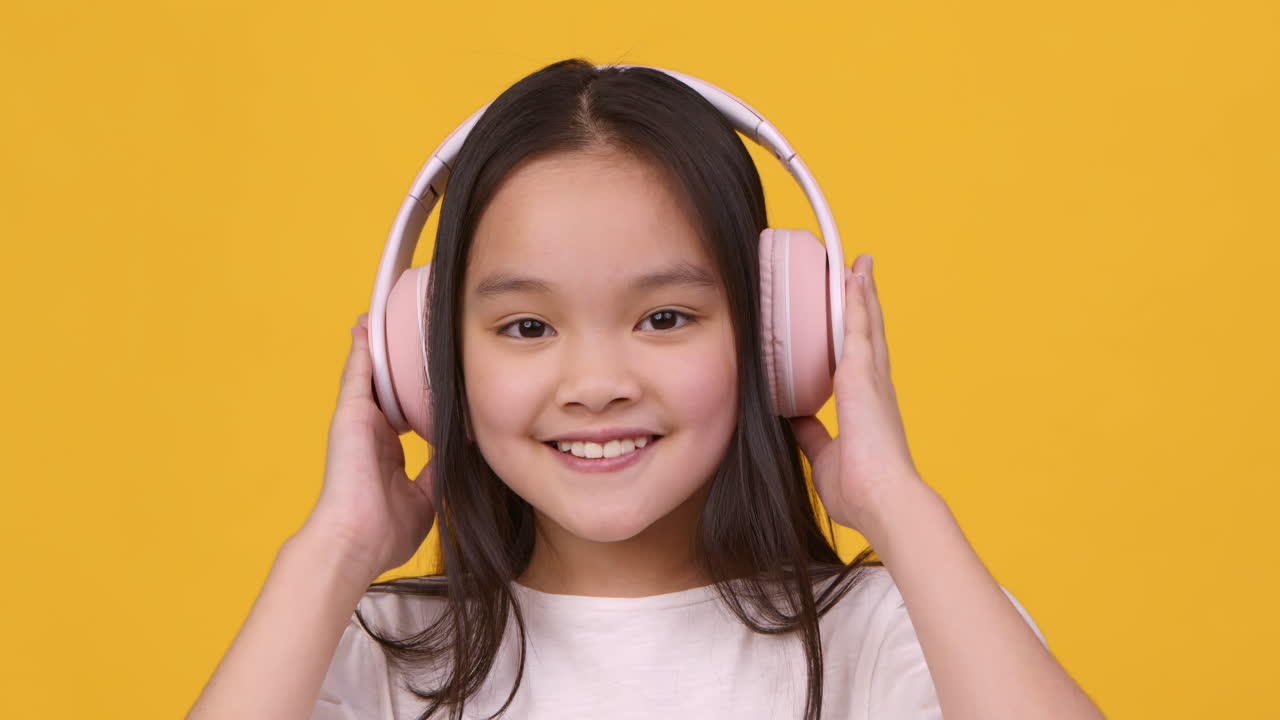 분홍색 헤드폰을 입은 어린 소녀
