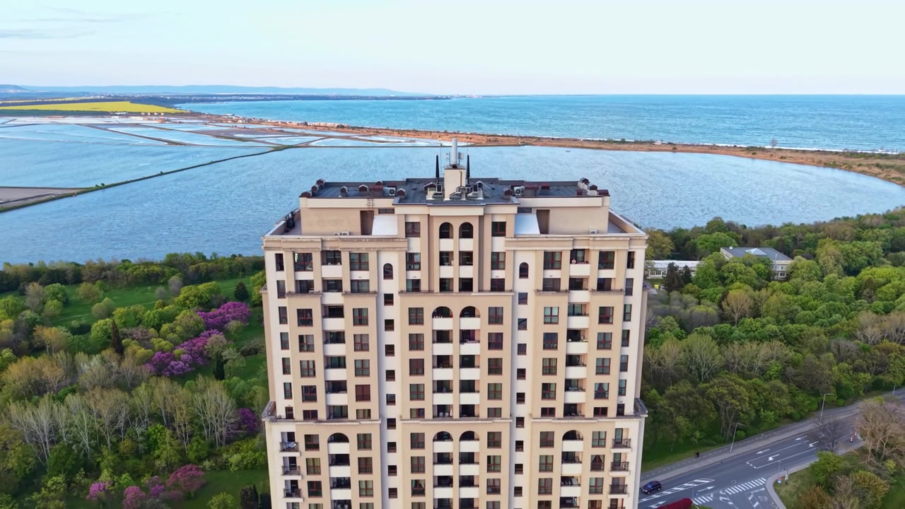 Vista costiera di un edificio alto vicino all'acqua con campi sullo sfondo in una giornata limpida al mattino