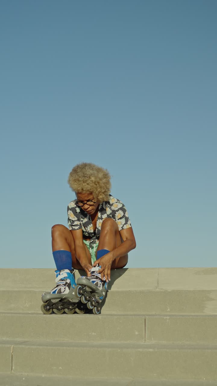 Woman sitting on stairs with roller skates