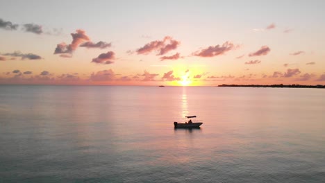 Still-drone-shot-of-boat-sitting-in-water-at-sunet