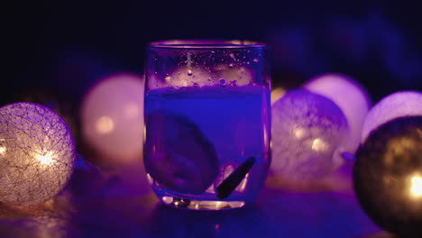 ice blocks falling into a lowball glass of a tonic beverage, with a beautiful dark atmoshere