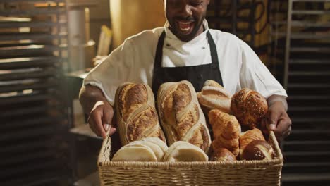 animation of happy african american male baker holding basket with diverse breads