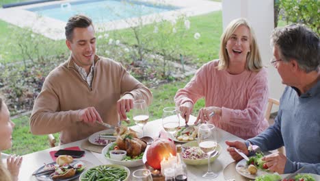 Video-of-happy-caucasian-grandfather-telling-story-at-outdoor-family-dinner-table