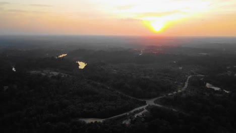 asombrosas imágenes cinematográficas de drones residenciales al atardecer de 4k después de que el problema de la deforestación consiste en casas, carreteras, árboles, lago e infraestructura en medio del bosque tropical ubicado en riau, indonesia