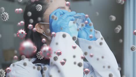 animation of virus cells over asian female doctor wearing face mask