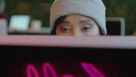 cerca hermosa mujer de negocios afroamericana usando computadora navegando en línea leyendo mensajes de redes sociales en un café de internet de oficina moderno