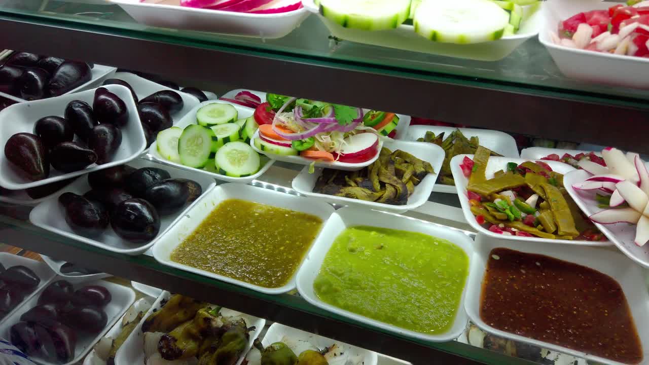 Colorful variety of authentic Mexican sauces and pickled vegetables on display in local market