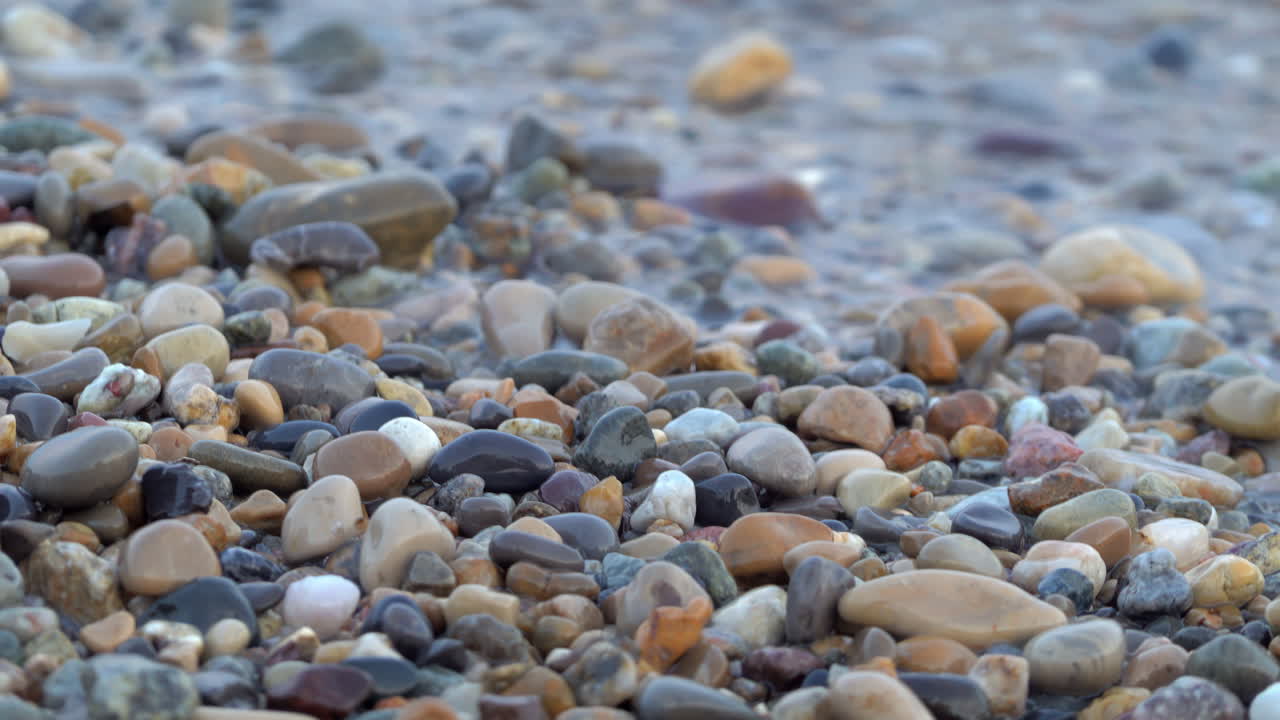 Close up of waves hitting the shore on a stone beach in Antibes, France