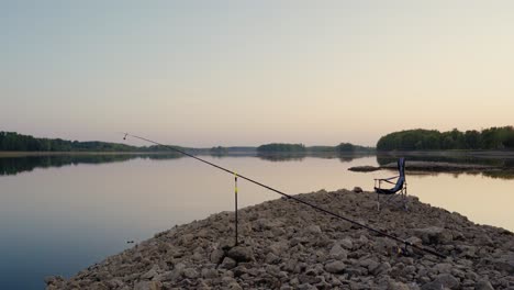 fishing setup on a rock by the river in a summer evening without a fisherman