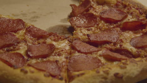 Pepperoni-Pizza-slice-being-taken-from-whole-pizza---close-up