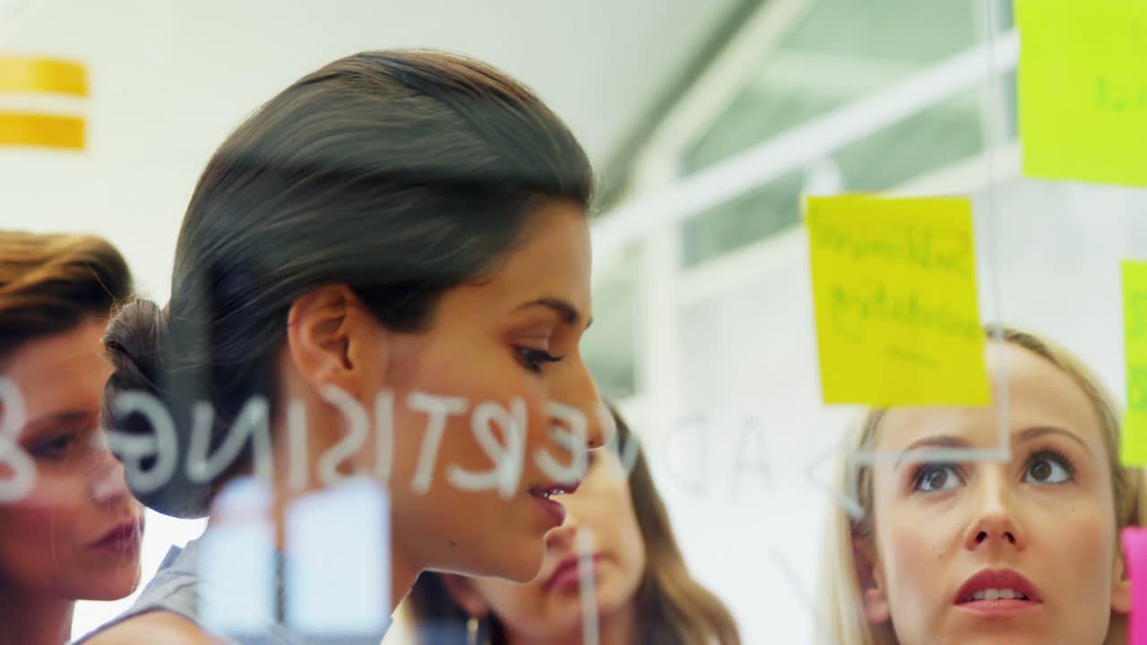 colegas discutiendo sobre las notas adhesivas en la pared 4k 4k