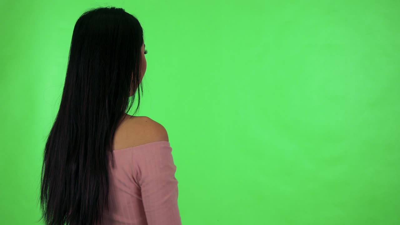 jovem mulher asiática atraente se alegra (atrás) - estúdio de tela verde