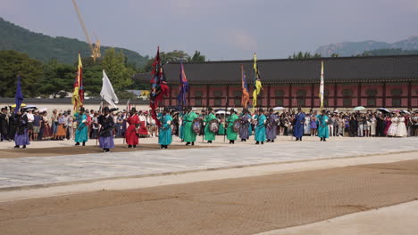 groups of tourists admire the majestic changing of the royal guards ceremony at gyeongbokgung palace in summer