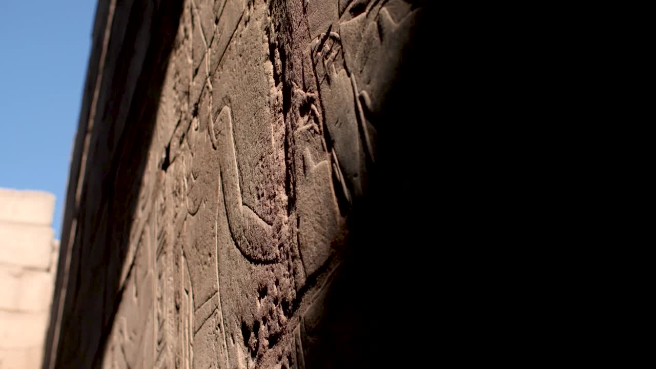 Detail view of sunrays hitting ancient writings in the Luxor Temple, Egypt.