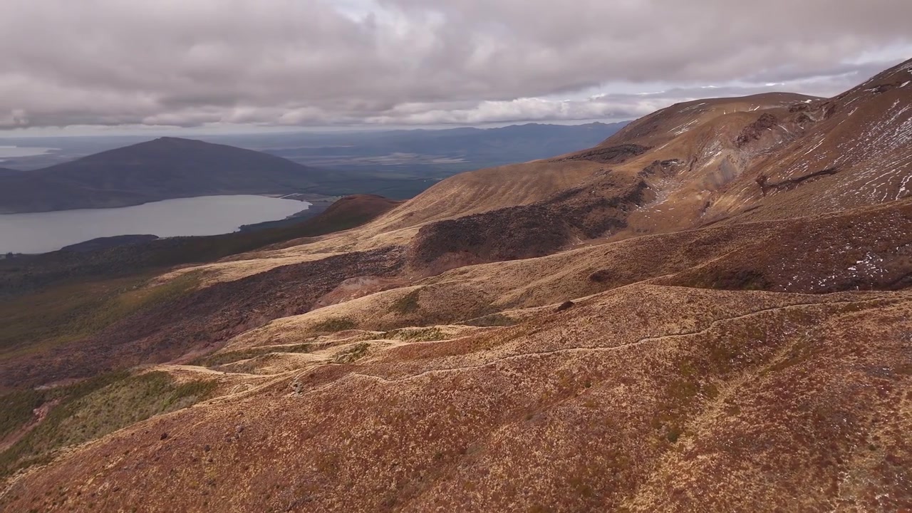 Vista panoramica del drammatico paesaggio vulcanico lungo il Tongariro Alpine Crossing nel Parco Nazionale di Tongariro, Isola del Nord, Nuova Zelanda, che mostra pendii vulcanici aspri e terreno alpino
