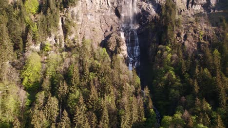 imágenes aéreas de drones empujando y levantando una impresionante cascada en grindelwald en los alpes suizos